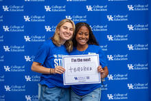 Two students holding a "I'm the next teacher" sign. 