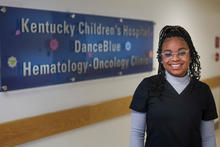 image of Treasure Newton standing in front of pediatric clinic sign
