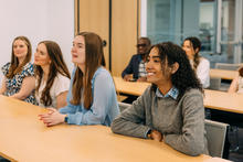 A group of students sit at desks in a classroom