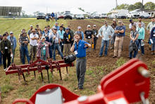 A large group of men and women standing listening to presentation at the 2025 Mechanical Weed Control Field Day