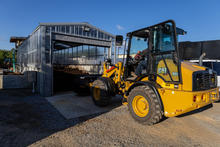 A composting building with a piece of machinery. 