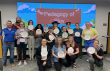 A group of instructors and graduate students holding their creations at the CELT "Pedagogy of Play" event.