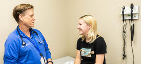 image of Annastasia Tipton with Louis Bezold, M.D. in an exam room