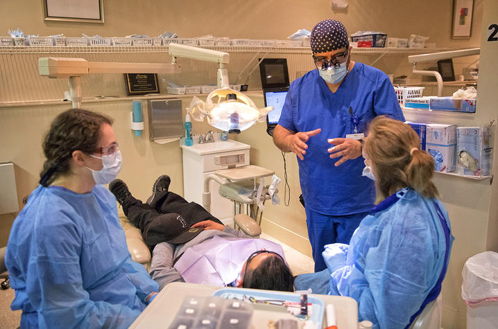 Dr. Fuentealba advises students Sarah Chhadh and Madalyn DuPlessis on care they will be providing to a patient.