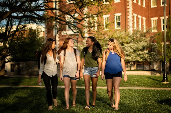 photo of 4 female students walking toward camera from Miller Hall