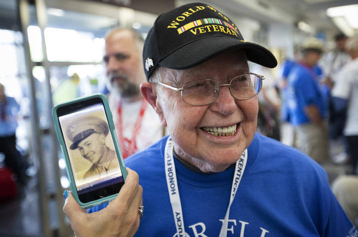 Photo of Cecil Hill, a World War II veteran, posing next to a photo of him in service. 