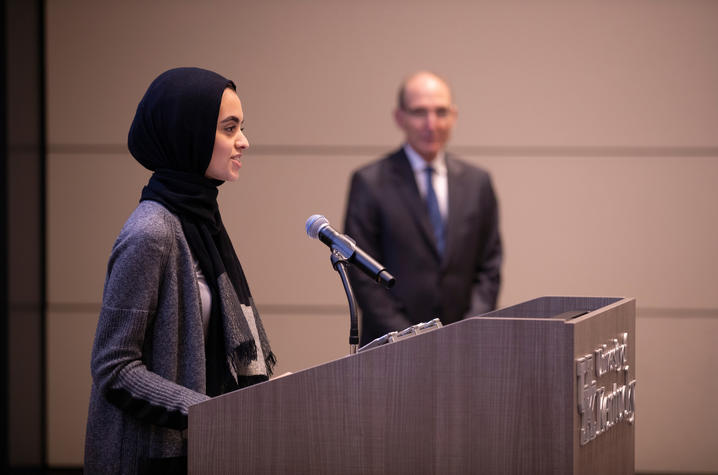 photo of Hadeel Abdallah speaking at BOT meeting with President Capilouto in background