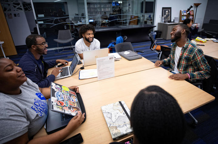 photo of 4 students seated talking with Eli Caldwell in MLK Center