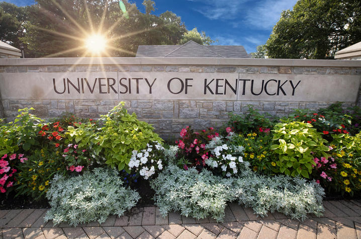 Stone wall labeled University of Kentucky decorated with blooming flowers