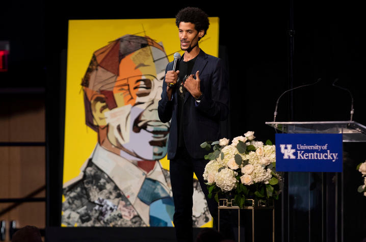 photo of Imar Hutchins with portrait of Lyman T. Johnson