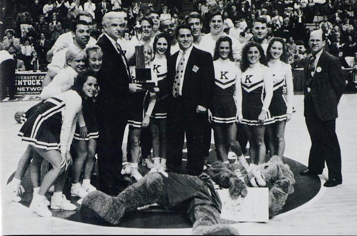 black and white photo of UK Cheerleading recognized at Rupp with trophy - 1996 Kentuckian