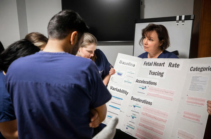 photo of Dr. Emily Cunningham displaying an educational board for students.