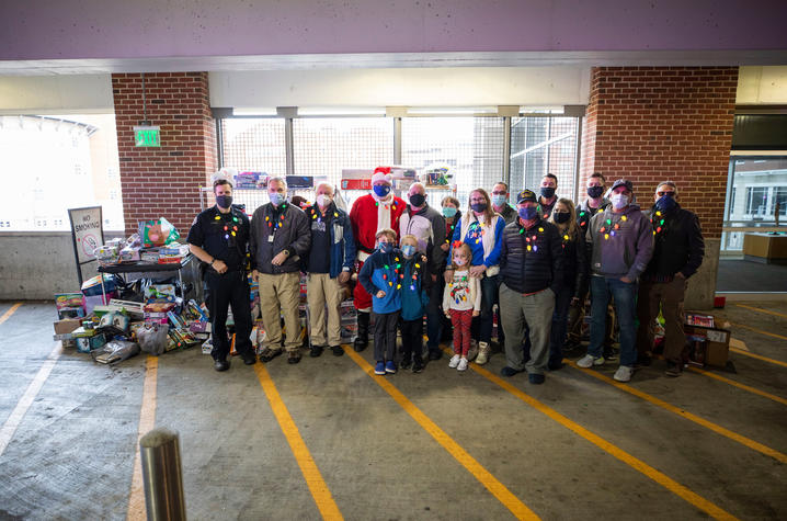photo of UK Police personnel, the Jonathan Ard family and 3M employees help deliver four police cruisers full of toys to KCH. 