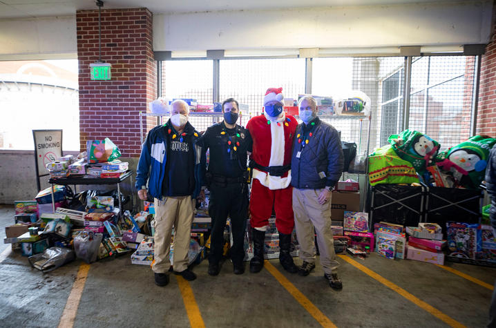 Photo of Don Mitchell, Sgt. Wesley Tyler, Chief Joe Monroe (Santa), and Lt. Greg Hall from UK Police and all the toys behind them.