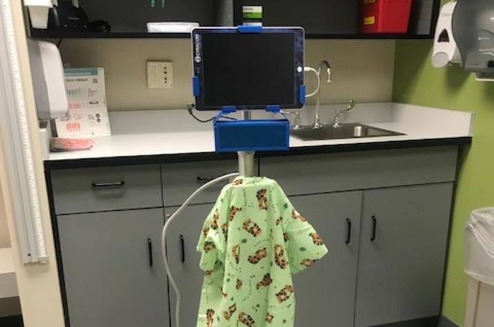 Video Remote Interpreter wearing a child's hospital gown