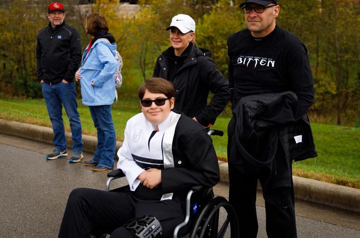 michael in his marching band uniform sitting in a wheelchair, ready to play with the front ensemble