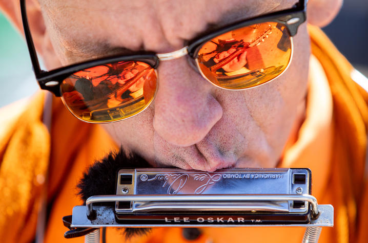 Brian Belknap simultaneously plays a harmonica and a guitar while performing for people passing by at Ferry Plaza. Photo by Jack Weaver.