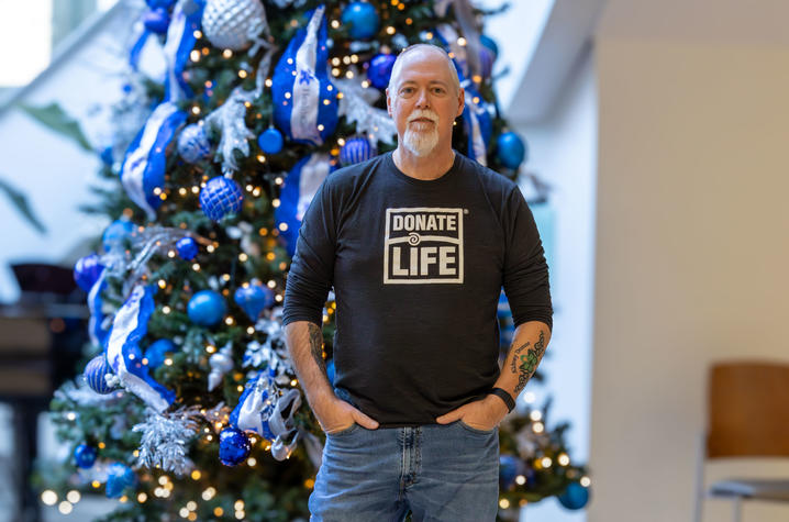 Image of Tom Coleman standing in front of a christmas tree