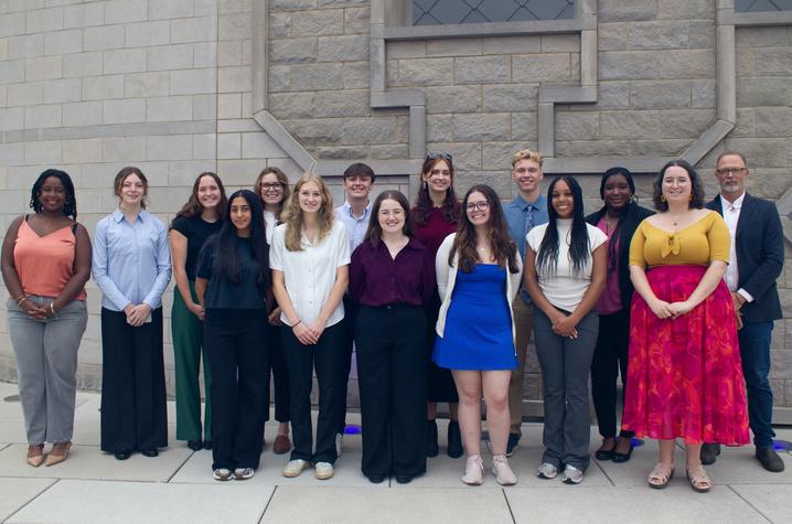 photo of UK Sustainability interns A group of students and a faculty member pose for a photo in front of a stone building.