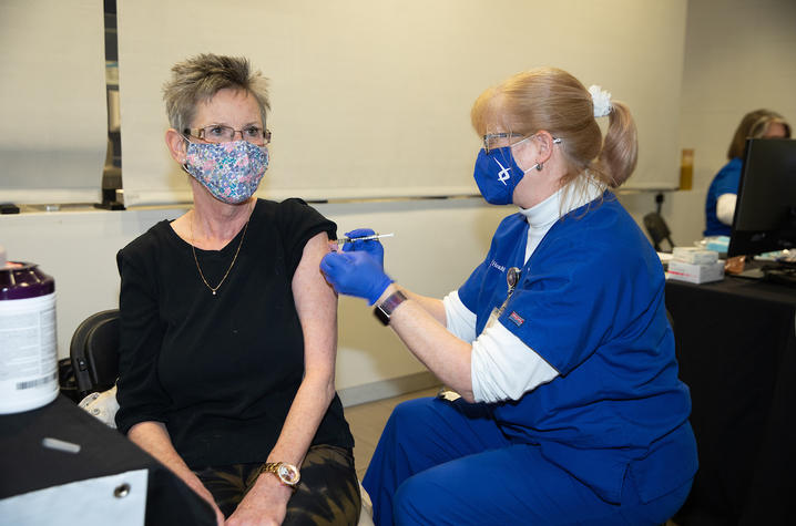 Image of Lynn Kelso administering a COVID vaccine