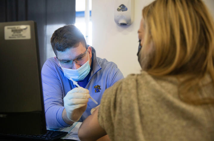 Image of Colin Goodfellow administering a COVID vaccine at the UK vaccine clinic