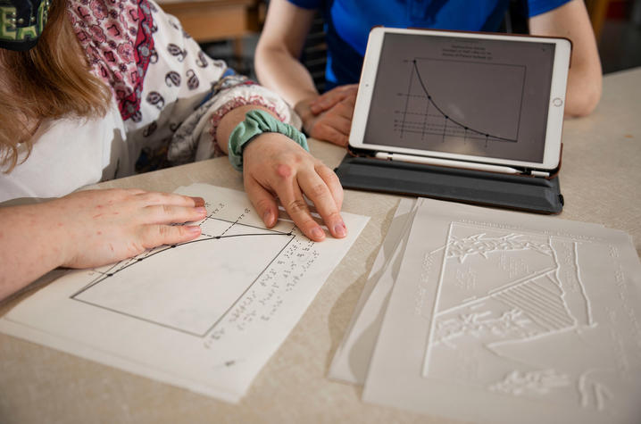 photo of Sydney Clark reviewing tactile graphics