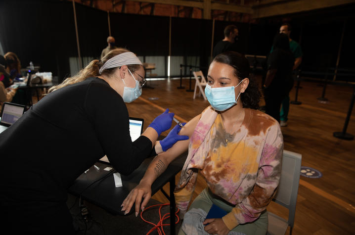 Photo of a female student getting a vaccine shot at the Blue Box Theater