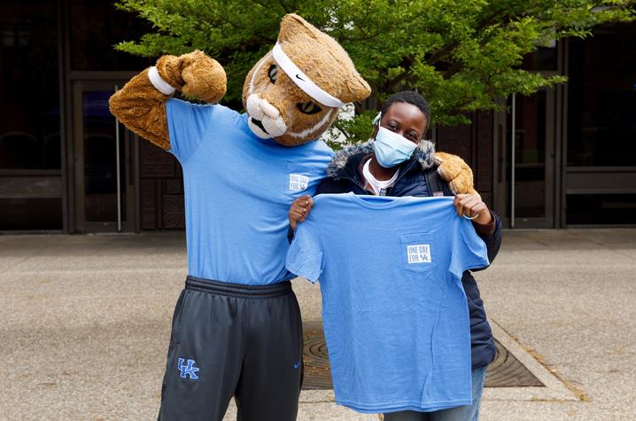 Photo of the UK Wildcat mascot with a woman holding a "One Day for UK" T-shirt.