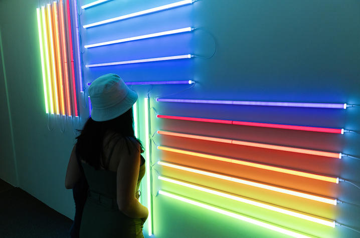 photo of student looking at neon artwork at UK Art Museum's "Coloring" exhibition
