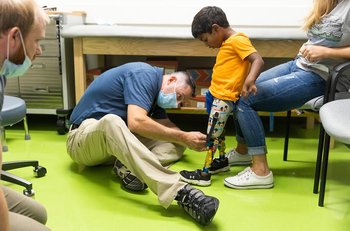 image of prosthetist Eric Miller making adjustments to Solomon's prosthetics