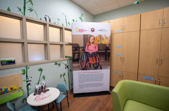 image of the inside of the Panda Cares room with green sofa and panda themed art on the walls