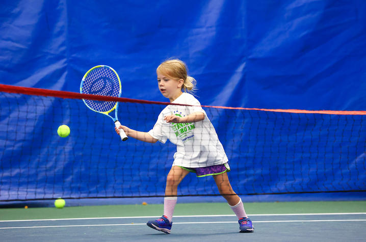 young patient swings at a tennis ball