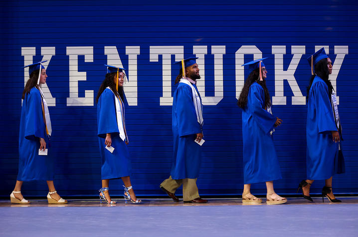 photo of students walking in caps and gowns