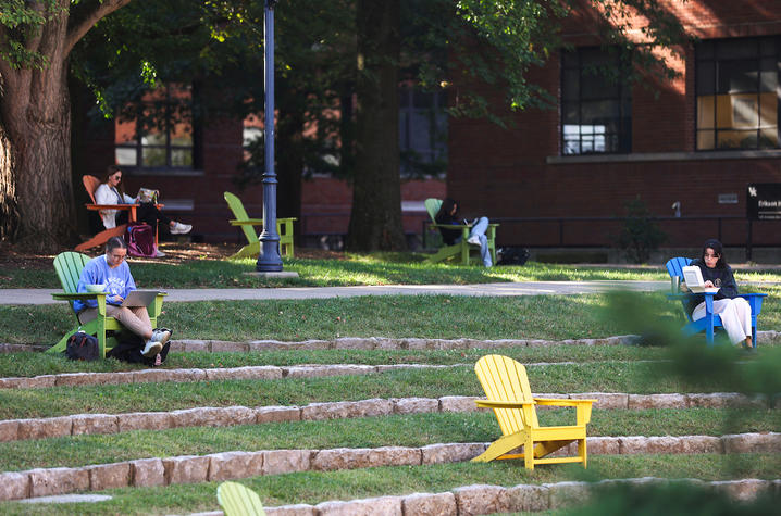 Students study in adirondack chairs near Memorial Hall Amphitheater