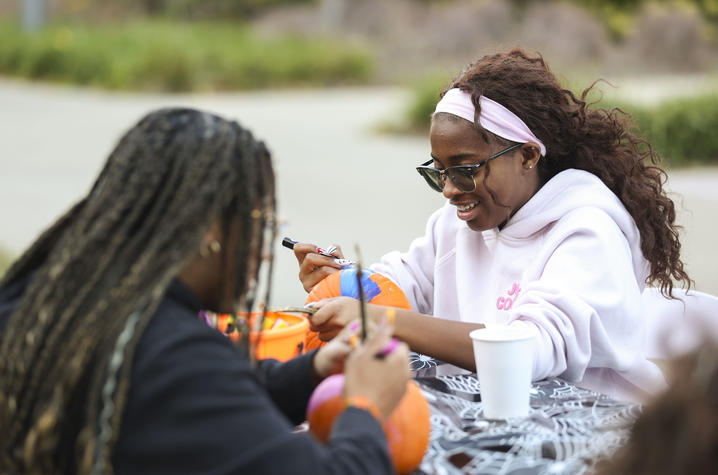 Two students carving pumpkins.