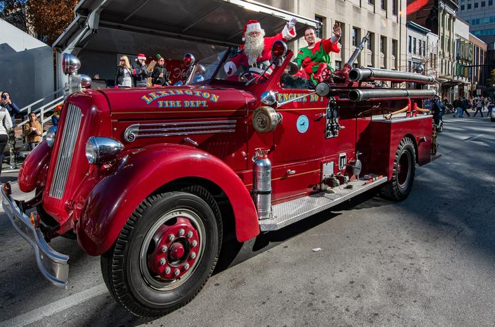 santa riding in a parade on a firetruck