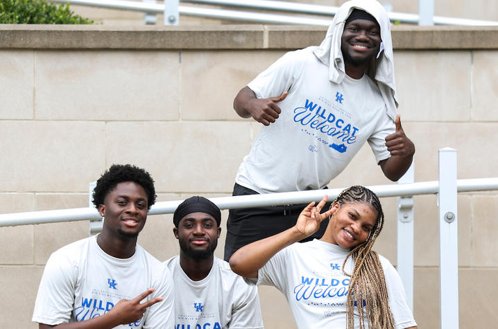 Four Big Blue Move-In volunteers smile and pose together in matching Wildcat Welcome shirts.