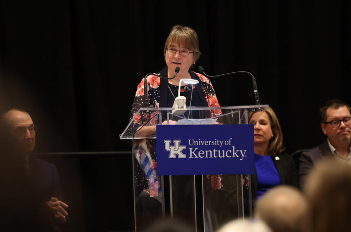 Woman with glasses standing at a podium