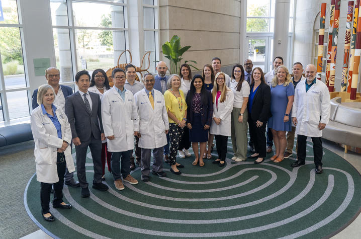 Group photo of approximately 20 members of the University of Kentucky Gill Heart & Vascular Institute Ventricular Assist Device team, including physicians, nurses and staff, standing together in the hospital lobby.