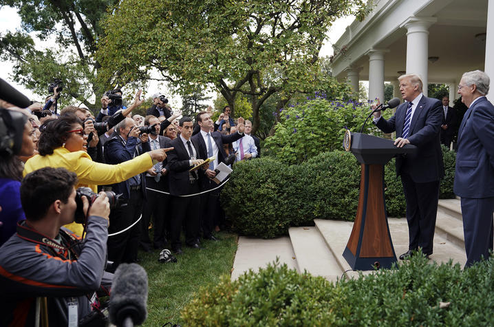 April Ryan, at left in yellow, has a question for President Donald Trump 