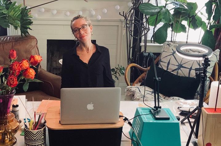 photo of Aubrey Nibert seated in her studio with laptop to teach GSA visual art online