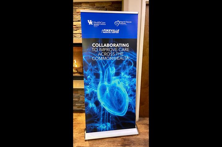 A vertical banner displays UK HealthCare and Pikeville Medical Center logos above a blue graphic of a human heart and blood vessels, with the text “Collaborating to Improve Care Across the Commonwealth.”