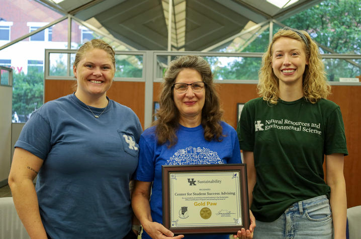 three people holding a certificate 