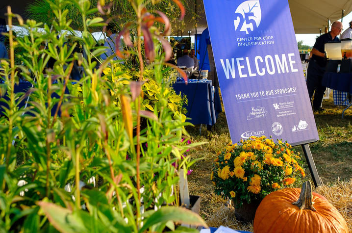 UK Center for Crop Diversification 25-year anniversary event signage surrounded by foliage 