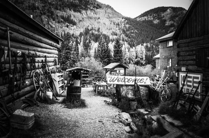 black and white Alethea Devary photo of items between to buildings with mountain scape in back