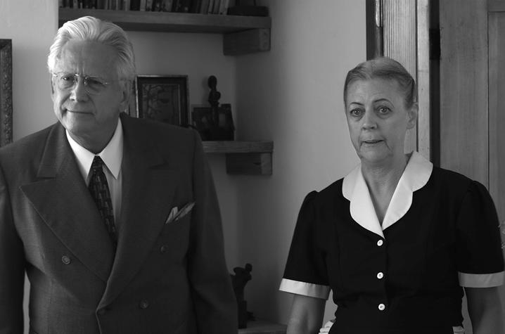 black and white photo of still from "Cemetery Tales" of actor in suit and actress in maid costume