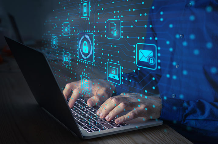 Man at keyboard with floating icons depicting locks and security