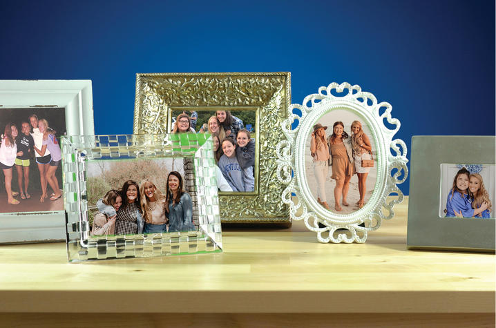Photo of several frames with photos in them sitting on a table