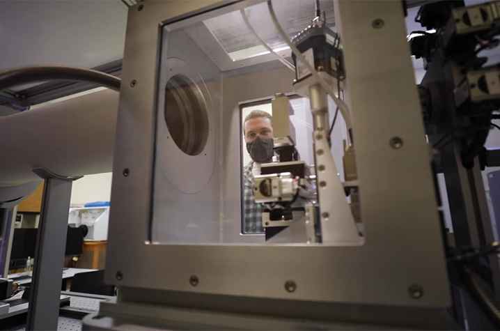 photo of Electron Microscopy and Materials Characterization Core A gloved and masked researcher loads a sample into an x-ray scattering machine.