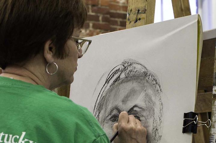 photo of student working on drawing at Fine Arts Institute